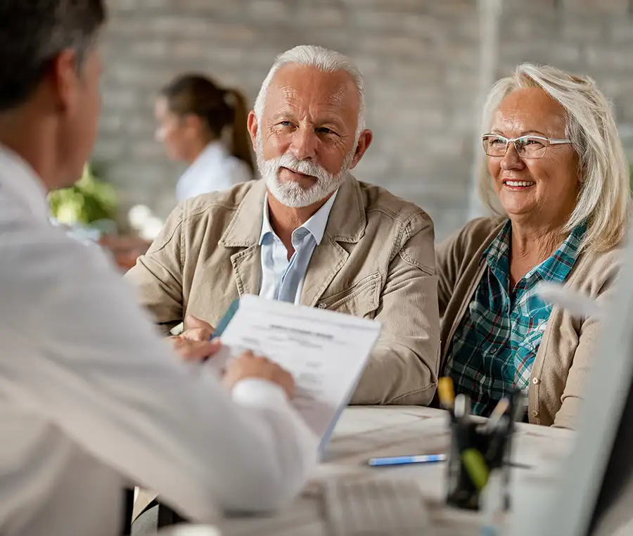 Older couple speaking with agent, discussing options for medicare enrollment - Alton, IL - St. Louis Metro East